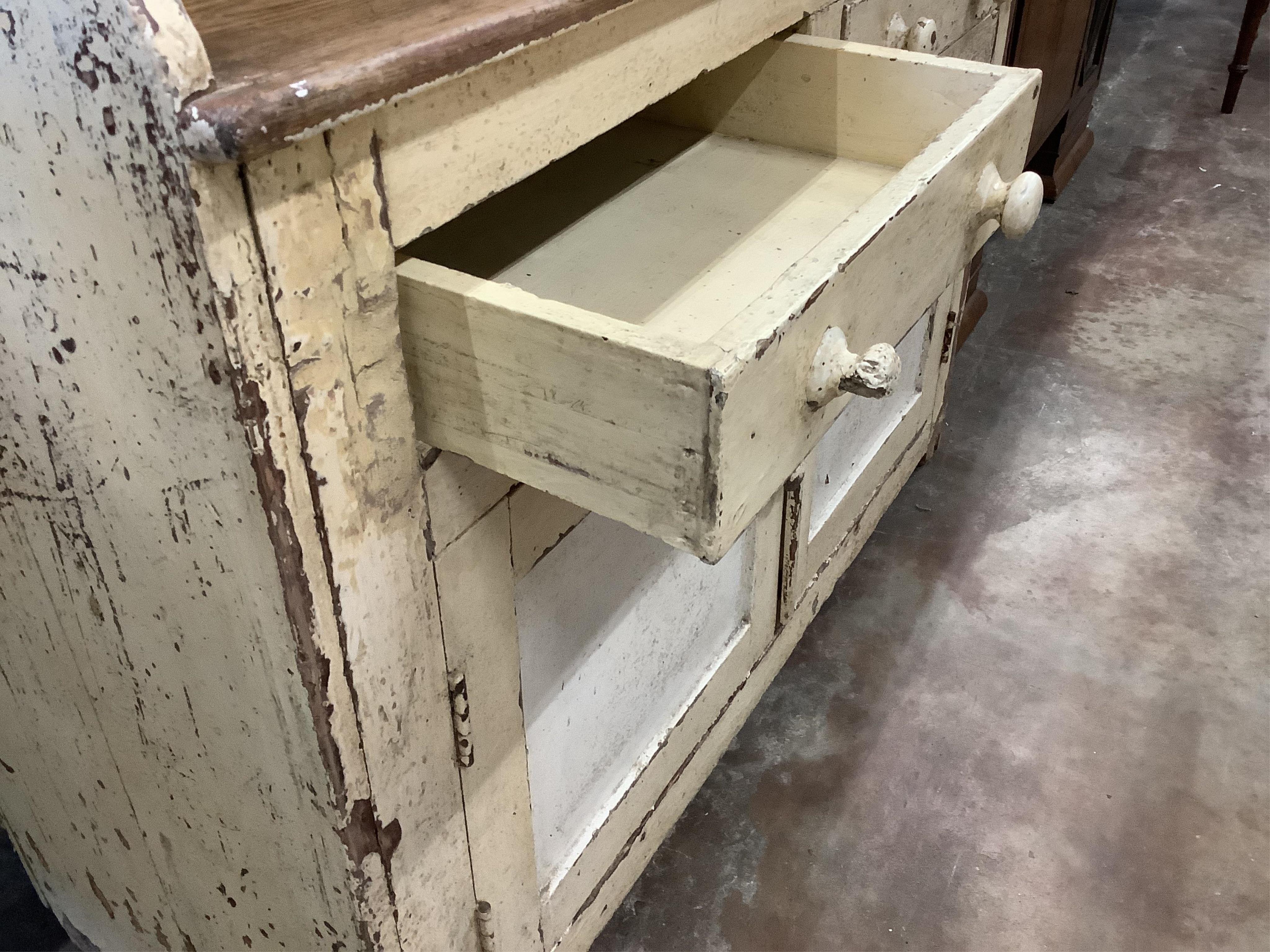 An early 19th century Irish painted pine dresser with boarded rack, width 126cm, depth 49cm, height 210cm. Condition - fair